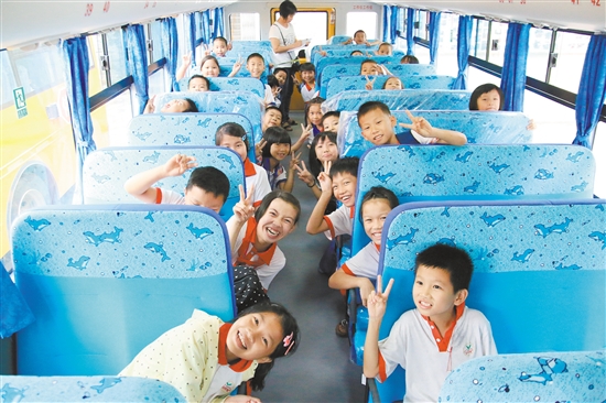 坐上“大鼻子”校车，开心的孩子们纷纷比出胜利的手势。